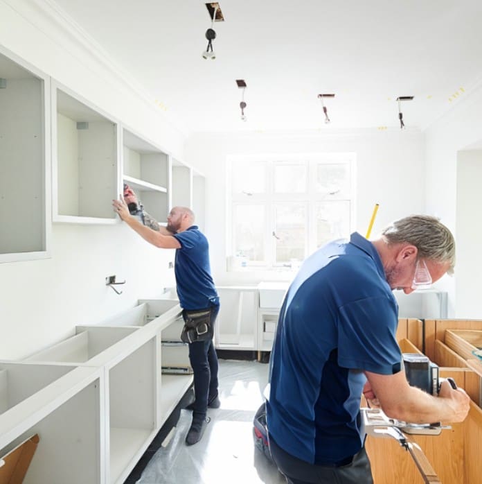 builders fitting new kitchen in bath