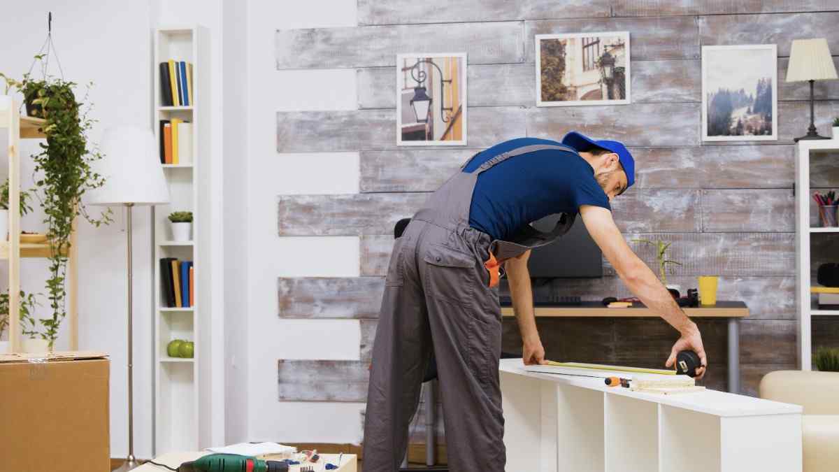 furniture assembly worker standing reading instruction using tape measure worker tools 1