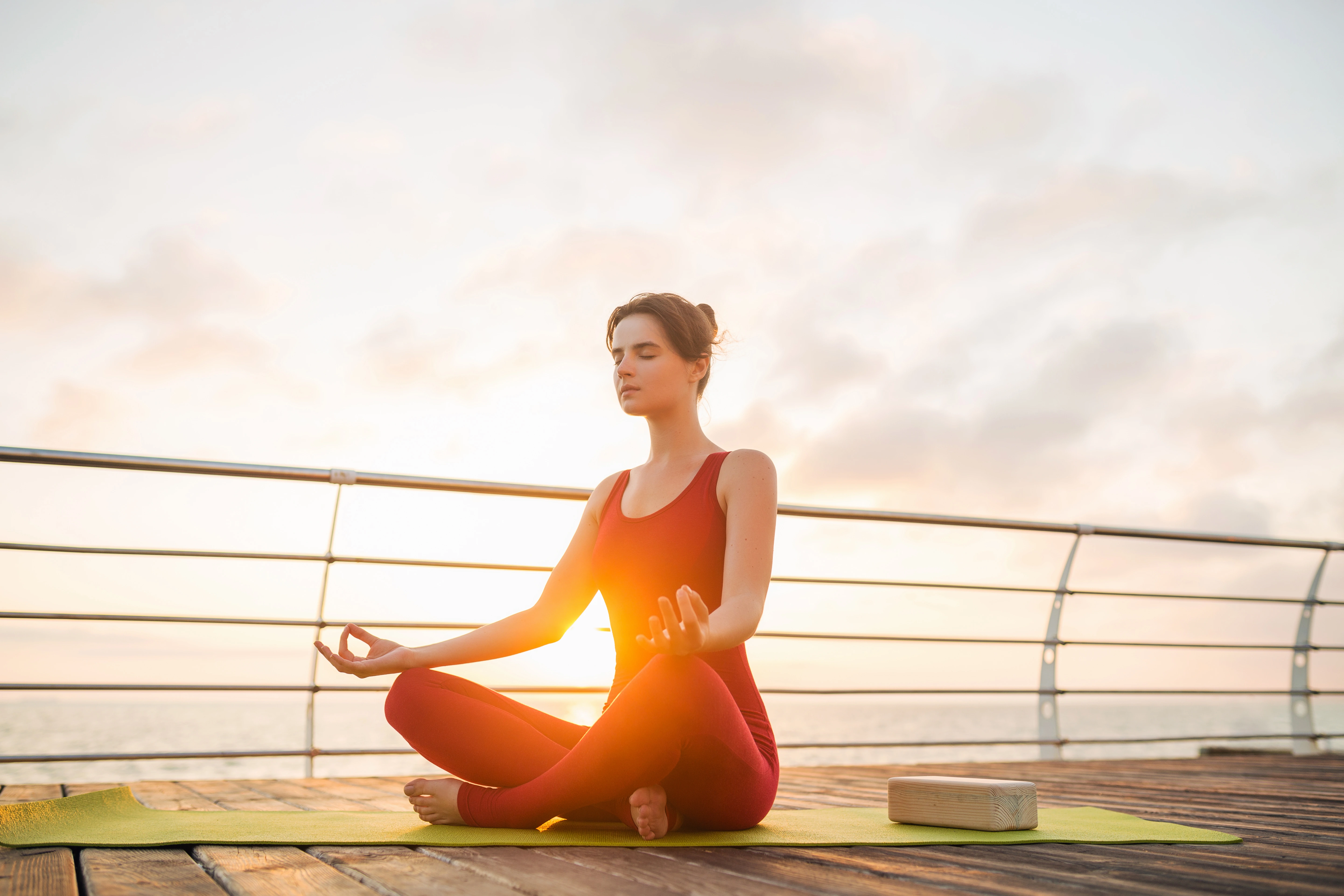 young slim beautiful attractive woman doing yoga morning sunrise by sea healthy lifestyle
